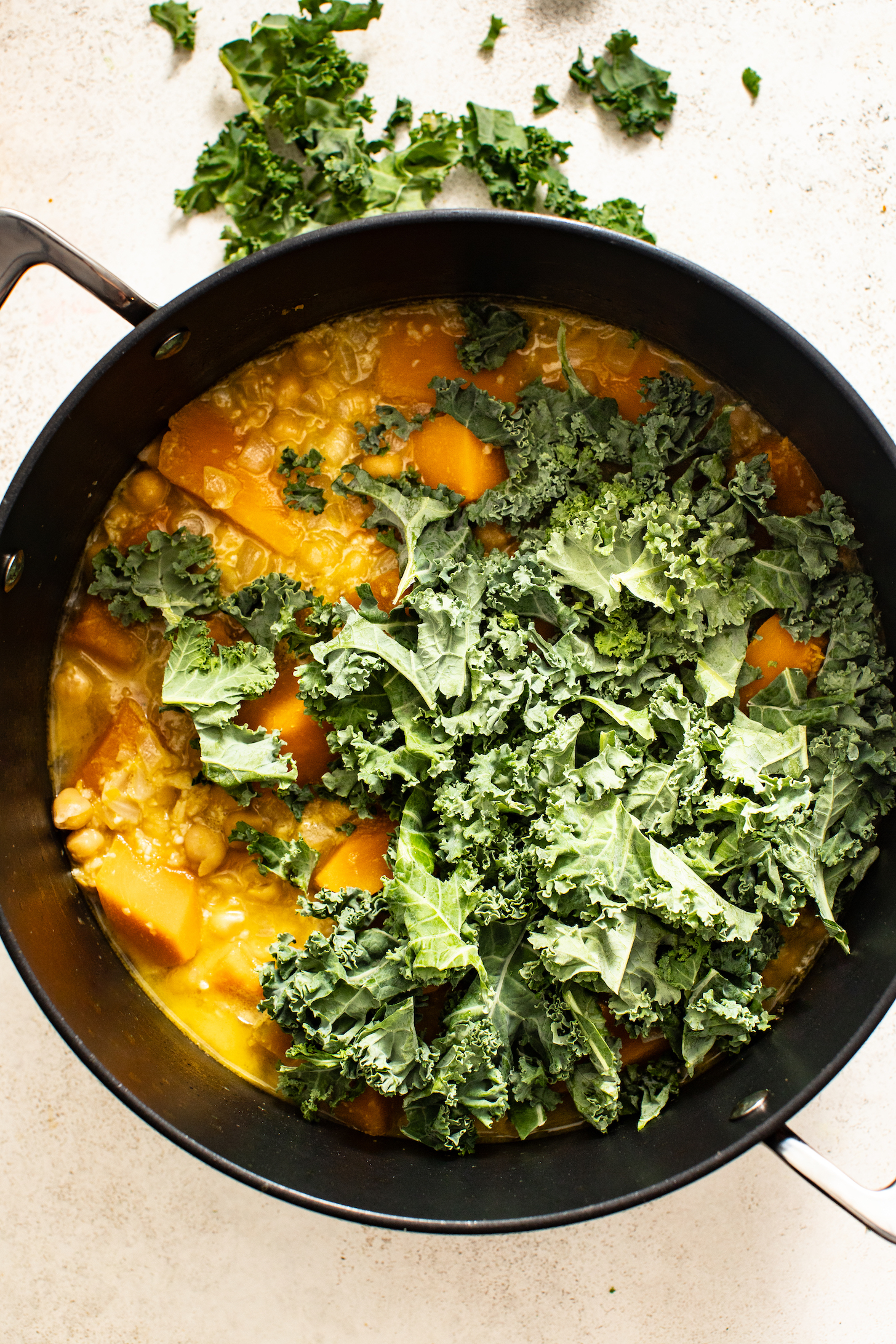 Chopped kale resting on top of a pot of soup