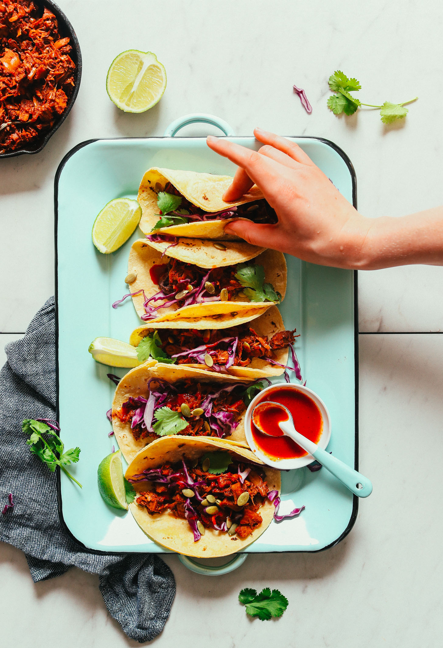 Grabbing a gluten-free vegan Jackfruit Taco from a platter