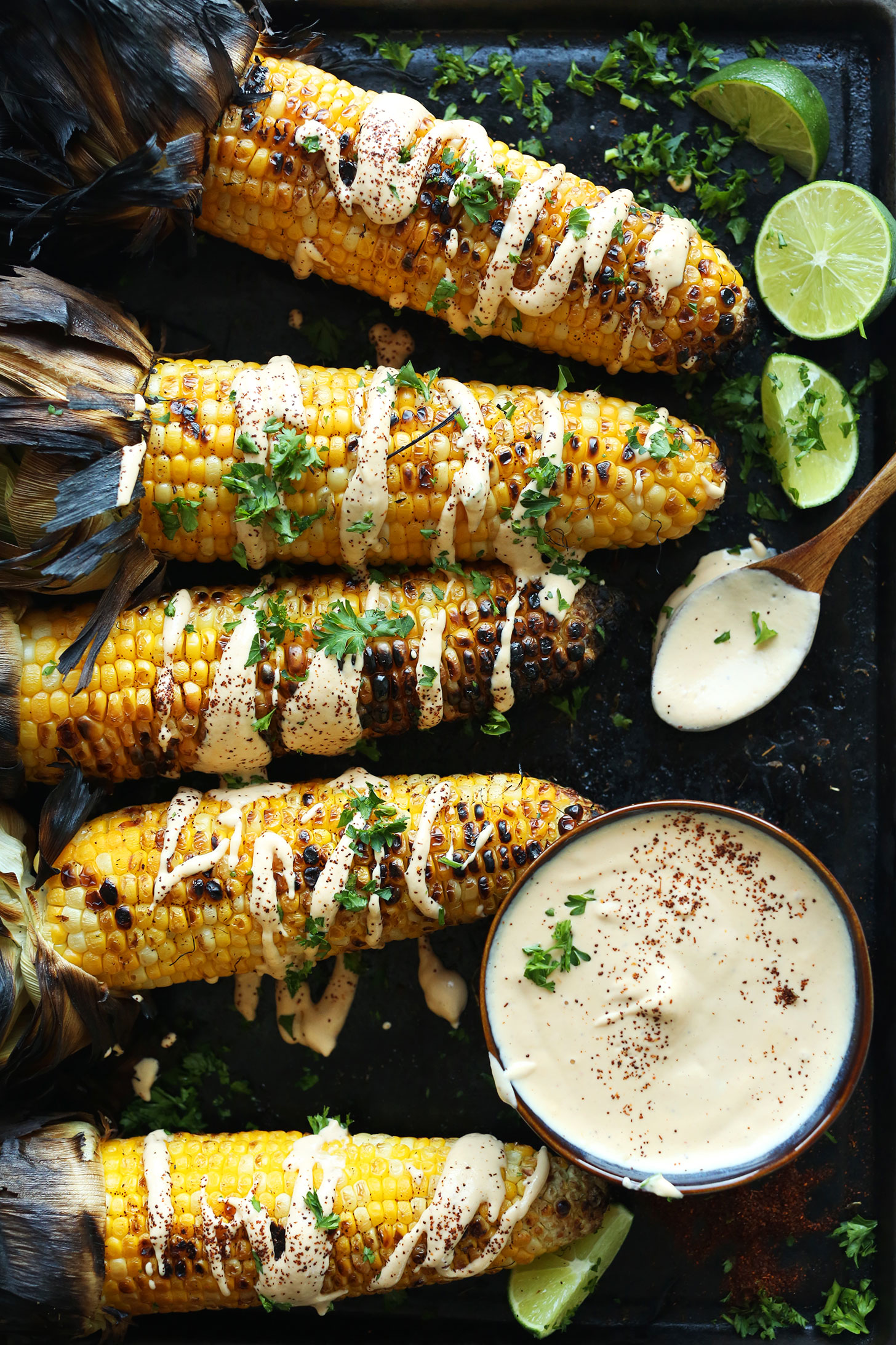 Grilled Corn Cobs drizzled with vegan Sriracha Aioli and fresh cilantro for a summertime recipe