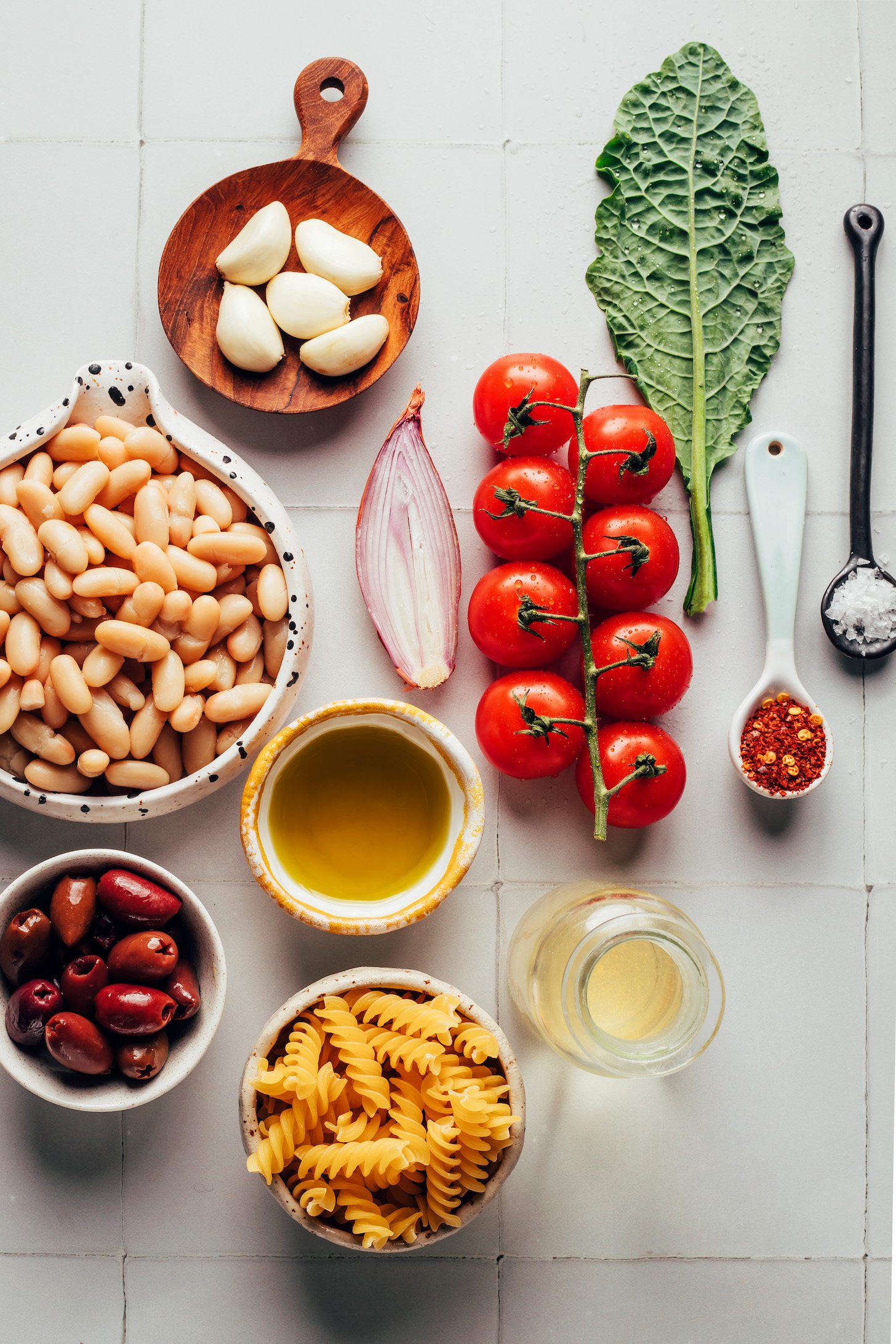 Pasta, olives, white beans, garlic, shallot, cherry tomatoes, kale, red pepper flakes, salt, and white wine