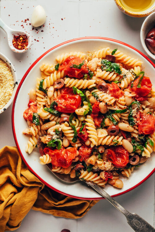 Overhead shot of a serving dish filled with garlicky cherry tomato and white bean pasta