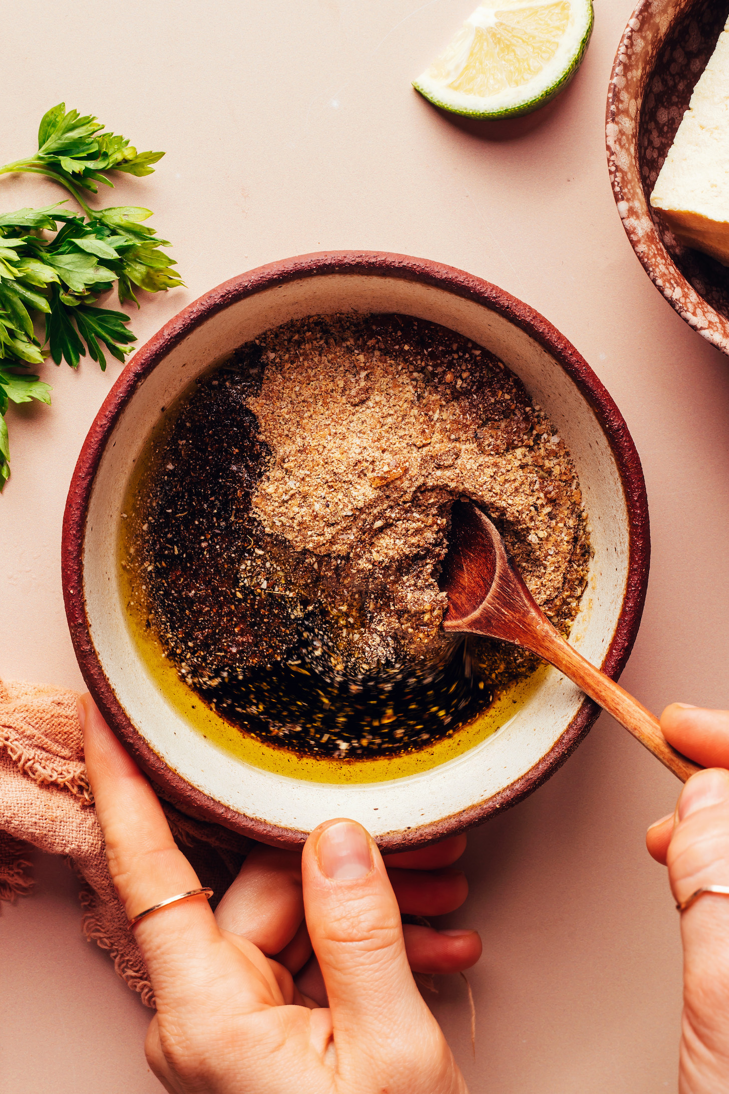 Stirring a bowl of jerk sauce made with spices, olive oil, tamari, and maple syrup