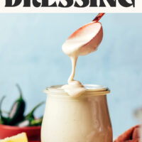 Cheesy jalapeño cashew dressing dripping from a spoon into a jar with text above that says ready in 5 minutes