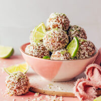 Bowl of no-bake coconut lime energy bites and lime slices