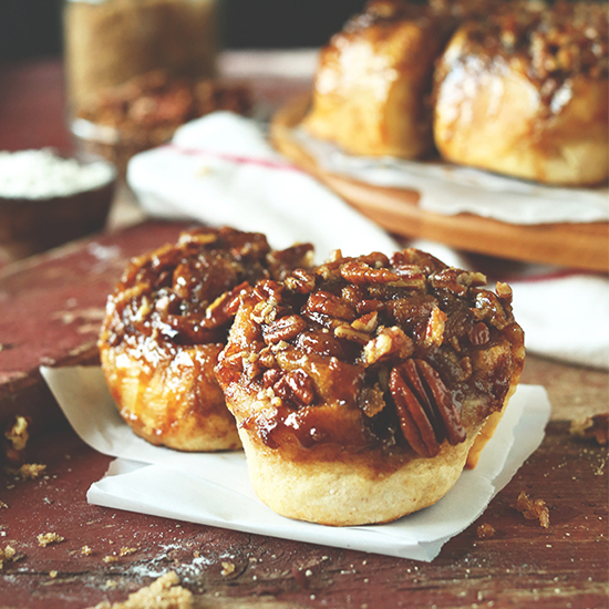 Two Vegan Sticky Buns on a piece of parchment paper
