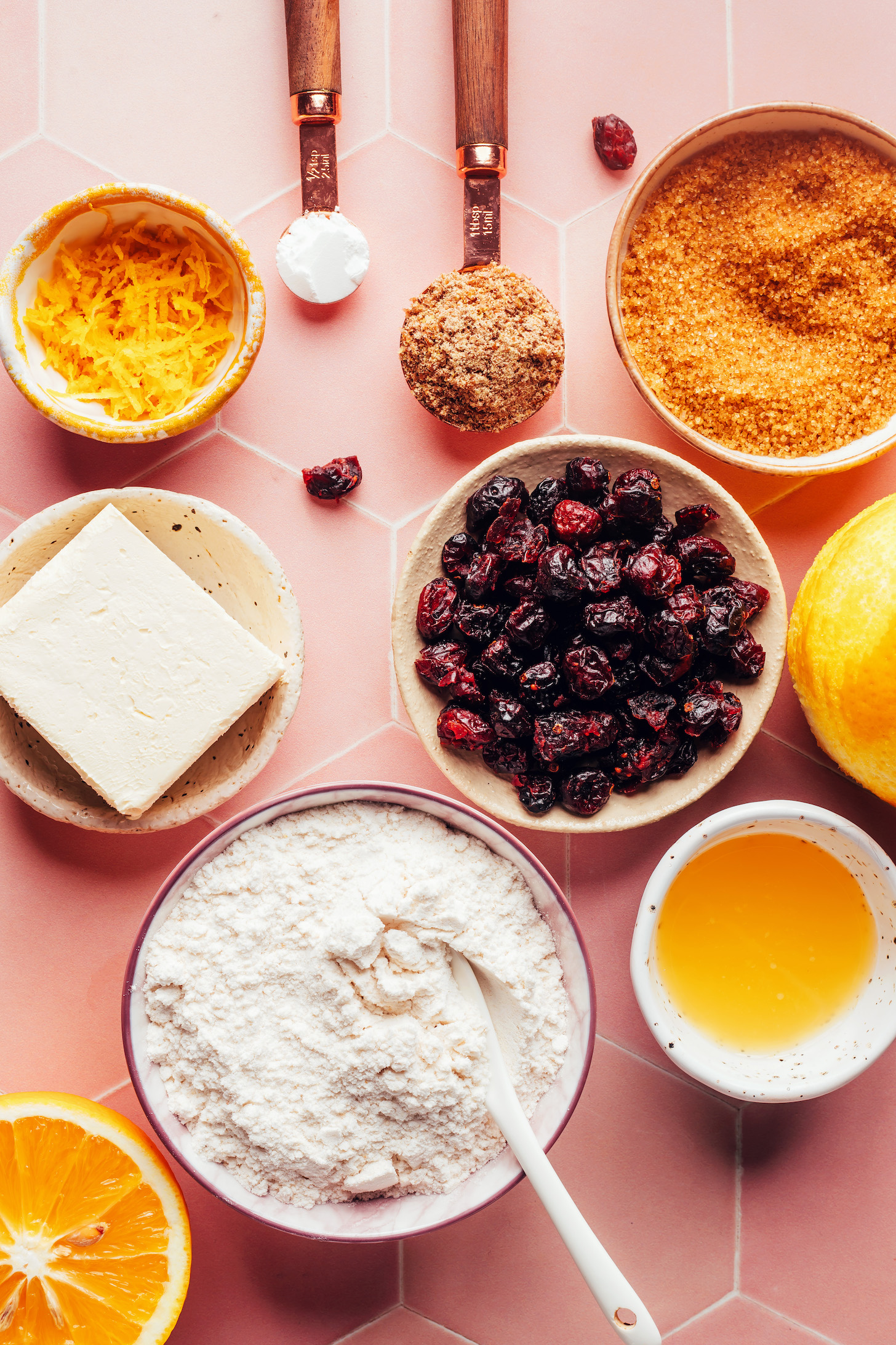 Orange zest, baking powder, flaxseed meal, brown sugar, a zested orange, dried cranberries, orange juice, gluten-free flour blend, and vegan butter