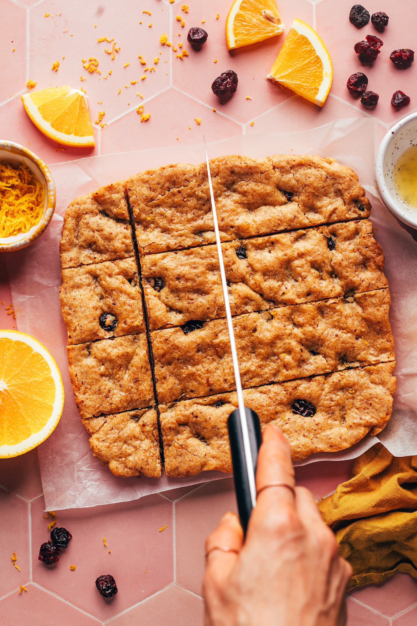 Using a knife to slice vegan gluten-free cranberry orange cookie bars