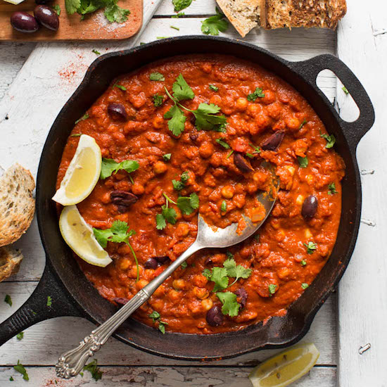 Spoon resting in a skillet of Vegan Shakshuka with fresh cilantro