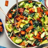 Overhead photo of a bowl of vegan taco salad with a serving spoon and fork in it